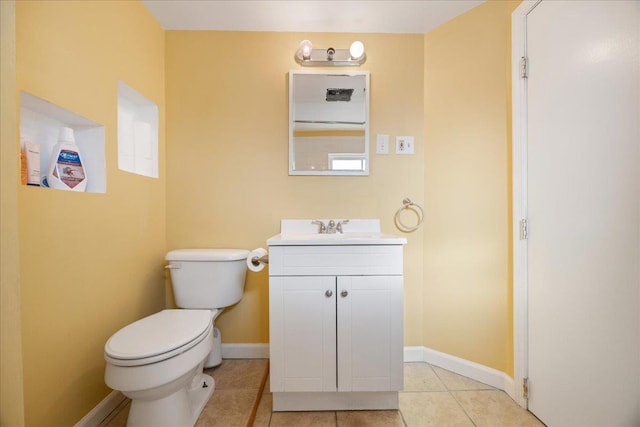 half bathroom with toilet, tile patterned flooring, baseboards, and vanity