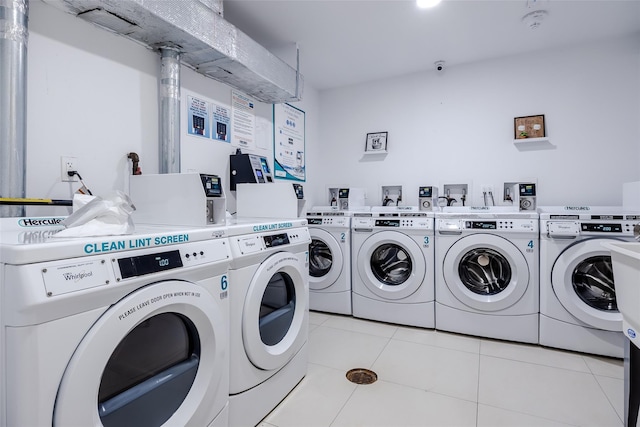 community laundry room with light tile patterned floors and washer and clothes dryer