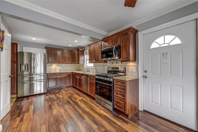 kitchen featuring appliances with stainless steel finishes, a sink, dark wood-style floors, and tasteful backsplash