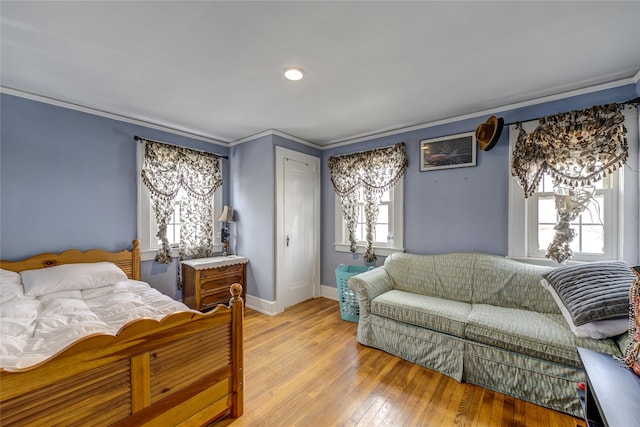 bedroom with light wood-type flooring, baseboards, and crown molding