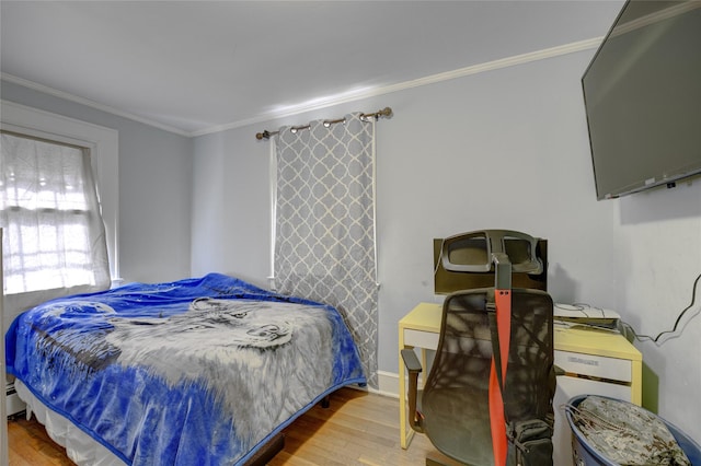 bedroom with ornamental molding, baseboards, and wood finished floors