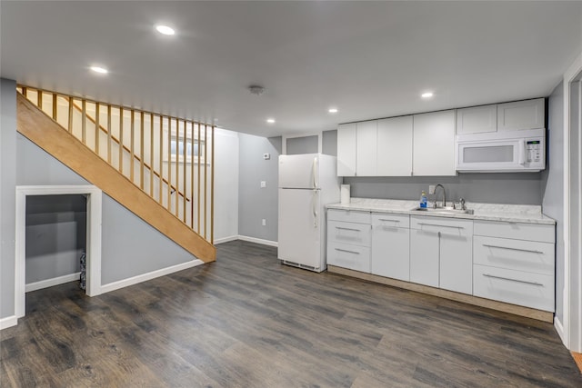 kitchen featuring dark wood-type flooring, white appliances, white cabinets, and a sink