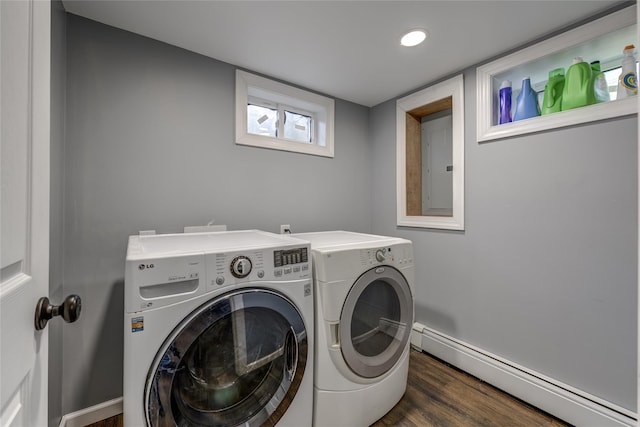 washroom with laundry area, wood finished floors, baseboard heating, electric panel, and washing machine and clothes dryer