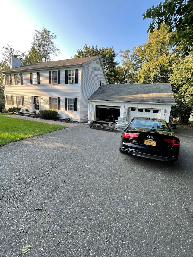 colonial inspired home featuring driveway and an attached garage