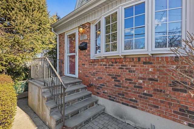 view of exterior entry featuring brick siding