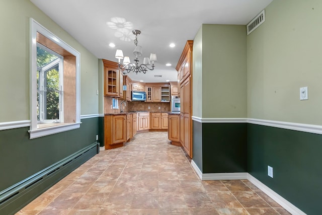 kitchen featuring tasteful backsplash, visible vents, glass insert cabinets, baseboard heating, and stainless steel appliances