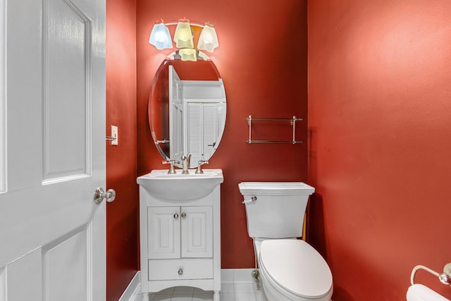 half bath with vanity, toilet, and baseboards