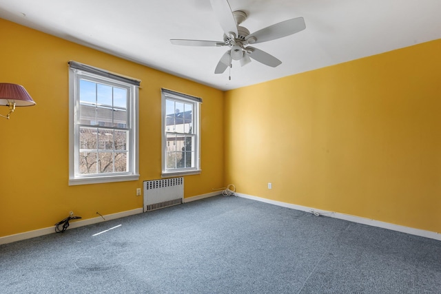 carpeted empty room featuring radiator heating unit, baseboards, and a ceiling fan