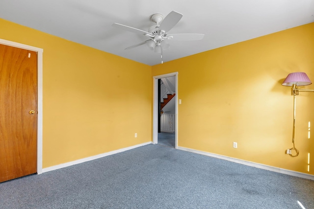 empty room with carpet, ceiling fan, and baseboards