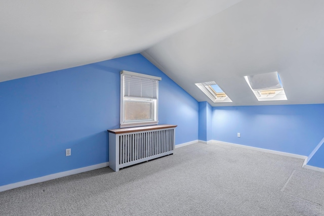 additional living space with lofted ceiling, radiator, baseboards, and carpet flooring