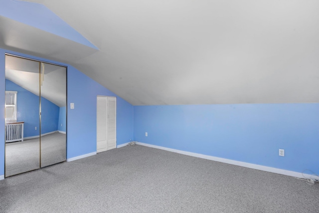 bonus room featuring radiator heating unit, carpet flooring, vaulted ceiling, and baseboards