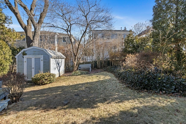 view of yard featuring an outdoor structure, a storage shed, and fence