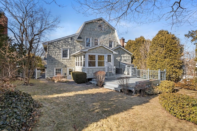 back of house featuring a yard, cooling unit, a wooden deck, and a gambrel roof