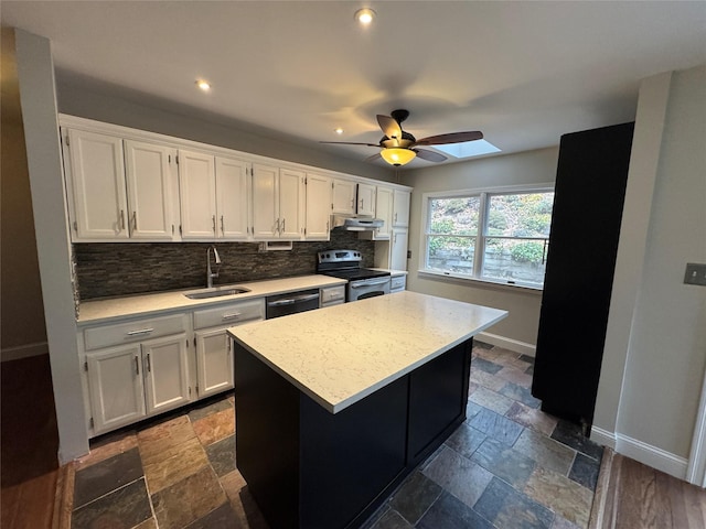 kitchen featuring stainless steel electric range oven, stone tile floors, white cabinets, a sink, and dishwasher