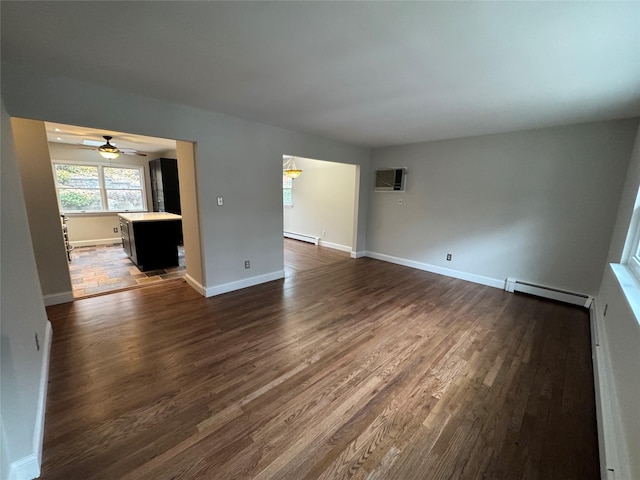 unfurnished living room featuring a baseboard heating unit, dark wood-type flooring, baseboard heating, and baseboards