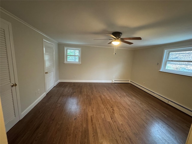 interior space with baseboards, multiple windows, ornamental molding, and dark wood-style flooring