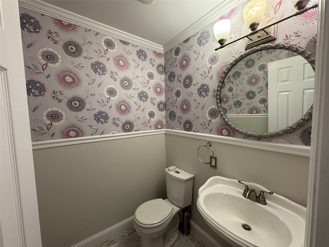 bathroom featuring toilet, a sink, and baseboards