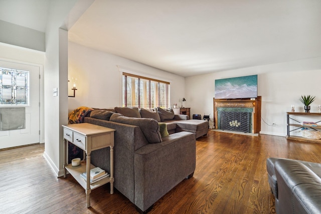 living room with a premium fireplace, baseboards, and wood finished floors