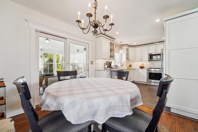 dining area featuring a chandelier, recessed lighting, and dark wood-style flooring