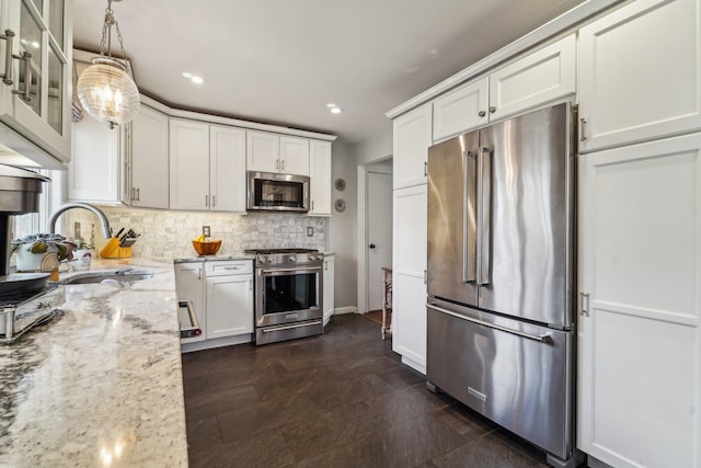 kitchen with a sink, white cabinets, appliances with stainless steel finishes, decorative backsplash, and glass insert cabinets