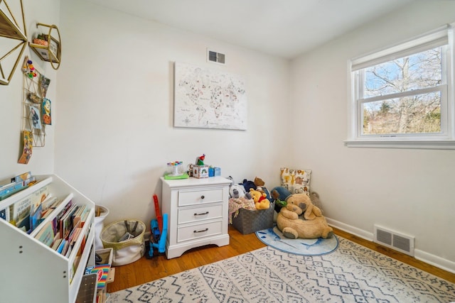 playroom featuring visible vents, baseboards, and wood finished floors