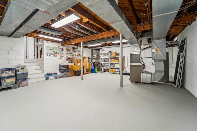 unfinished basement with concrete block wall and heating unit