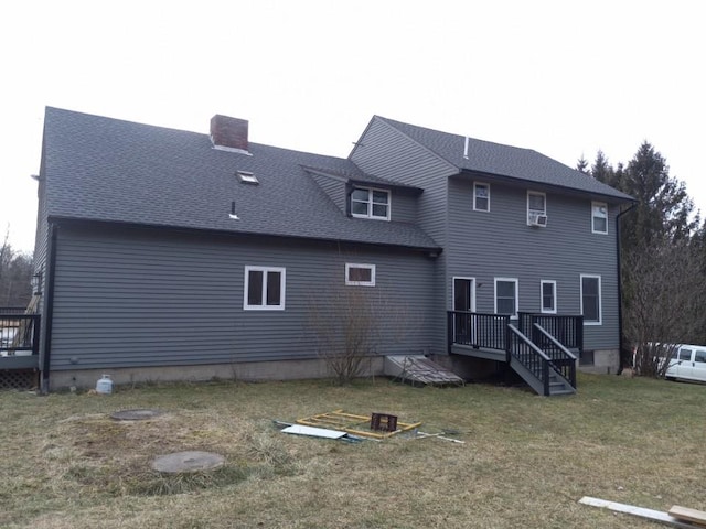 rear view of house featuring roof with shingles, a lawn, and a chimney