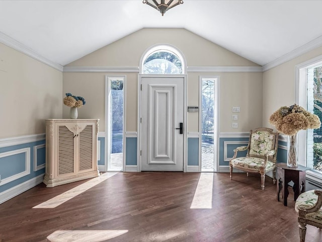 entryway featuring a wainscoted wall, crown molding, lofted ceiling, and wood finished floors