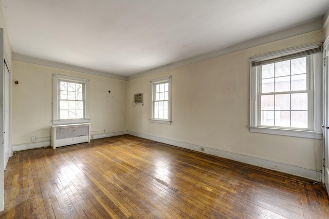 spare room featuring radiator, hardwood / wood-style flooring, and baseboards