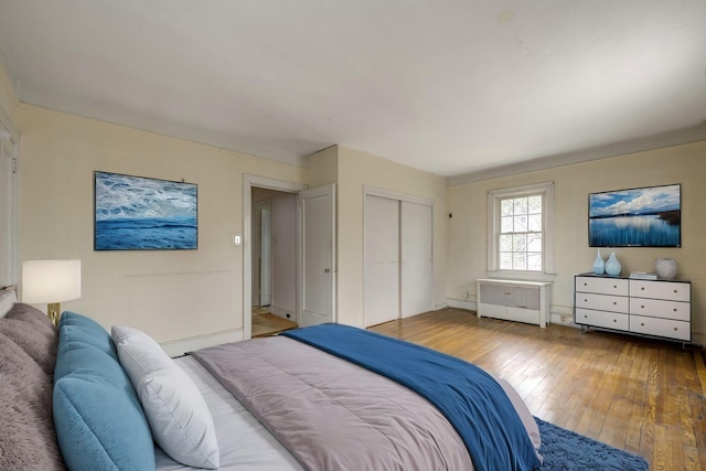 bedroom with a closet, baseboards, and hardwood / wood-style flooring