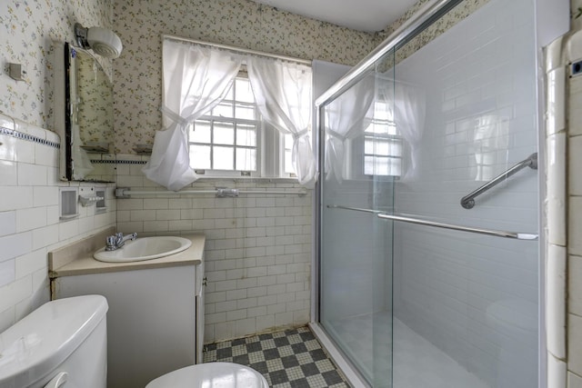 full bathroom with toilet, wallpapered walls, tile walls, and a wealth of natural light