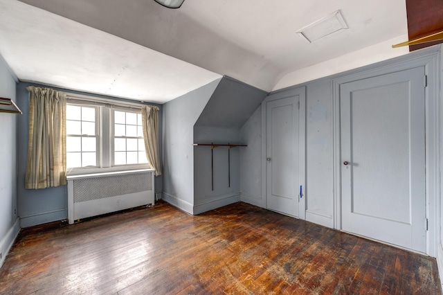 additional living space with lofted ceiling, hardwood / wood-style flooring, radiator heating unit, and baseboards