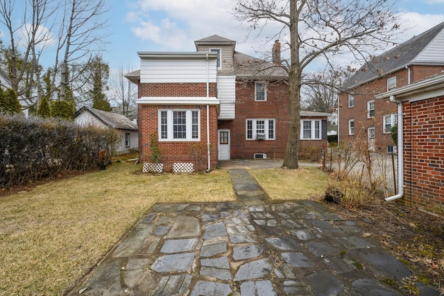 back of property featuring a yard, brick siding, and a chimney