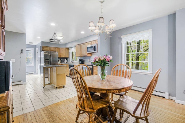 dining area with light wood-style floors, a baseboard radiator, and baseboards