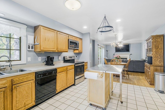 kitchen featuring light tile patterned floors, a sink, open floor plan, light countertops, and appliances with stainless steel finishes