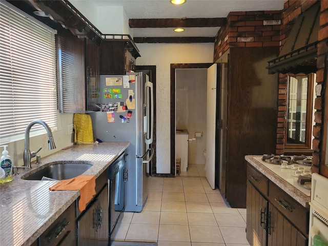 kitchen with dishwasher, a sink, light countertops, beam ceiling, and light tile patterned flooring