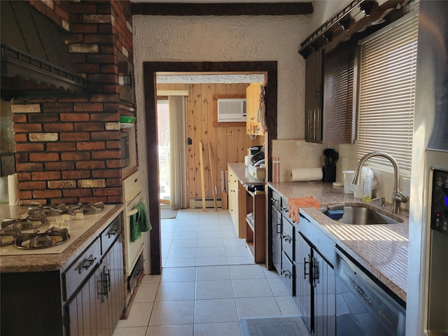 kitchen featuring white gas stovetop, dishwasher, a baseboard radiator, a sink, and light tile patterned flooring