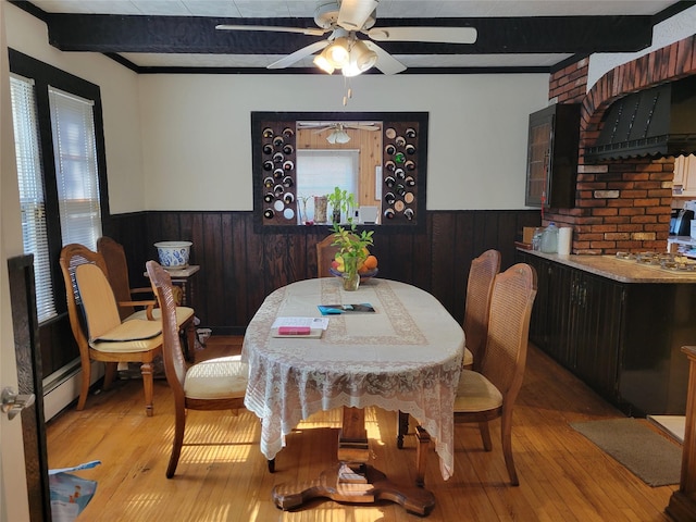 dining room featuring a wainscoted wall, a wealth of natural light, and beam ceiling