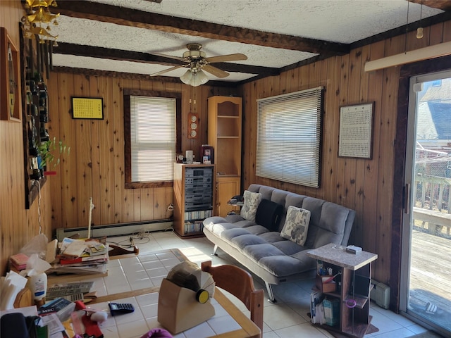 living area featuring light tile patterned floors, a textured ceiling, wood walls, a baseboard heating unit, and beam ceiling