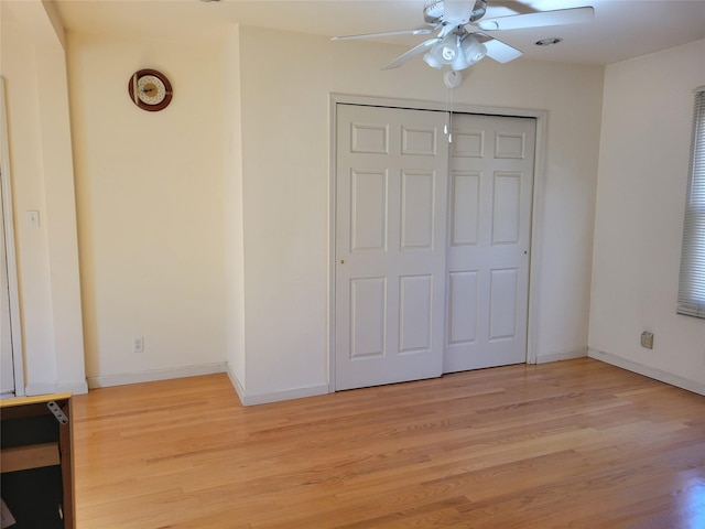 unfurnished bedroom featuring a ceiling fan, light wood-type flooring, a closet, and baseboards