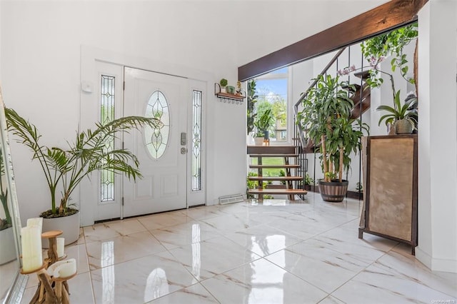 entrance foyer featuring marble finish floor and stairs