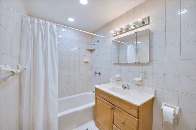 full bath featuring shower / bath combo, vanity, and tile walls