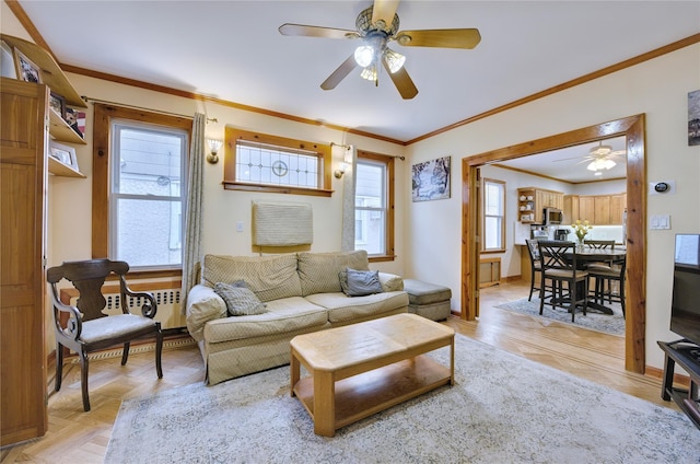 living room with baseboards, a ceiling fan, and crown molding