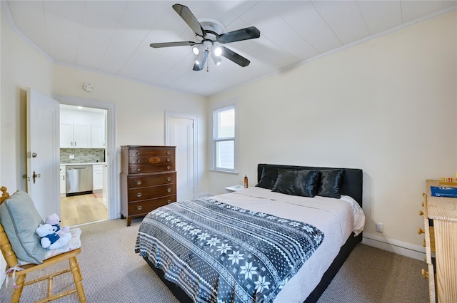 bedroom featuring light carpet, baseboards, ceiling fan, ornamental molding, and ensuite bathroom