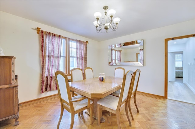 dining area featuring baseboards and a notable chandelier