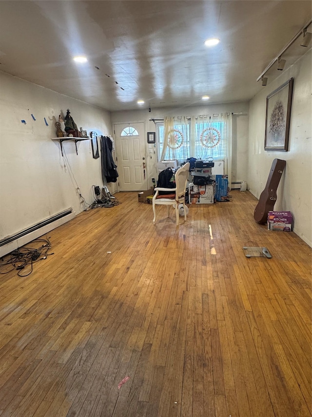 workout room featuring wood-type flooring and baseboard heating