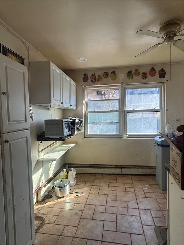 kitchen featuring white cabinetry, a baseboard heating unit, and ceiling fan