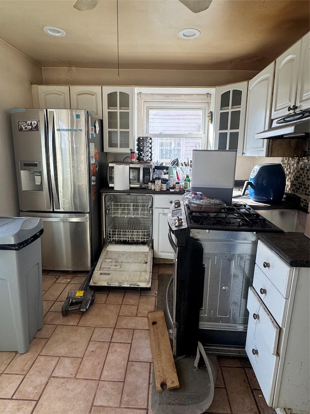 kitchen featuring under cabinet range hood, stainless steel appliances, dark countertops, and white cabinets