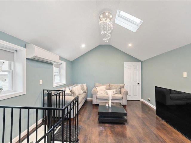 living room featuring a chandelier, vaulted ceiling with skylight, a wall unit AC, dark wood-type flooring, and baseboards