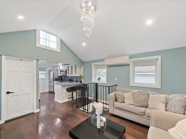 living room featuring plenty of natural light, dark wood finished floors, a notable chandelier, and a wall mounted air conditioner